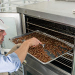 Mark Overbay checks on a batch of roasted nuts. (Photo courtesy of Big Spoon Roasters)
