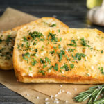 Tasty garlic bread with herbs on table